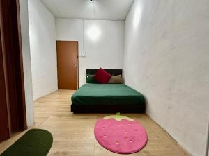 a room with a green bed and a pink rug at Home10#6pax#Netflix#NearAeonAlma&Lotus#BM# in Bukit Mertajam