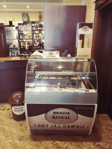 a display case in a shop with a box of donuts at Hotel "XAVIER" in Lubycza Królewska