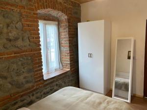 a bedroom with a brick wall and a white cabinet at Old House in Lagodekhi