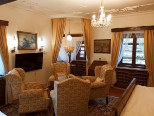 een woonkamer met stoelen en een televisie bij Boutique hotel & Wellness Spitzerova vila Eliška in Janovice