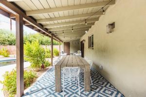 a patio with a wooden table and chairs at Heated Pool Outdoor Kitchen Patio Modern Design in Scottsdale +28 photos