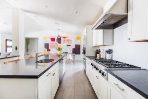 a kitchen with white cabinets and black counter tops at Heated Pool Outdoor Kitchen Patio Modern Design in Scottsdale