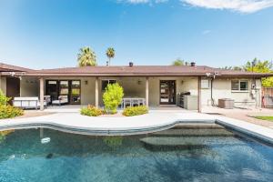 une maison avec une piscine en face d'une maison dans l'établissement Heated Pool Outdoor Kitchen Patio Modern Design, à Scottsdale