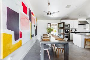 une salle à manger avec une table, des chaises et des peintures murales dans l'établissement Heated Pool Outdoor Kitchen Patio Modern Design, à Scottsdale