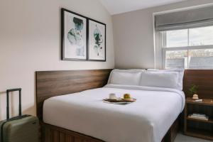 a bedroom with a bed with a tray of food on it at Sonder The Voyage in London