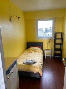 a small bedroom with a bed and a window at L'Imprenable vue mer in Crozon