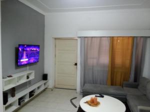 a living room with a couch and a tv on the wall at Borges Place in Praia