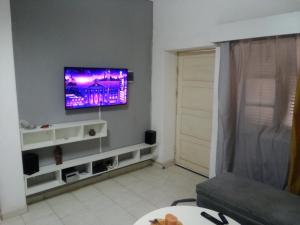 uma sala de estar com uma televisão de ecrã plano na parede em Borges Place em Praia