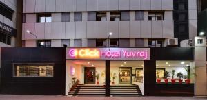 een gebouw met een bord dat clubhuis Kyu leest bij Click Hotel Yuvraj in Surat