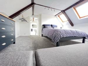 a bedroom with a bed and a dresser in it at Dolls House Cottage in Hilborough