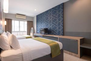 Habitación de hotel con cama y TV en iCheck inn Gems Center Silom, en Bangkok