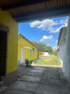 a view of a yellow house from an alley at Kuca za odmor Daca Bogojevo in Bogojevo