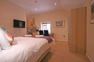 a bedroom with a large bed and a television at The Elephant Room in Ivinghoe