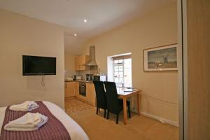 a bedroom with a bed and a table and a kitchen at The Elephant Room in Ivinghoe