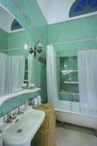 ein grün gefliestes Badezimmer mit einem Waschbecken und einer Badewanne in der Unterkunft Dar Chennoufi in Sicca Veneria