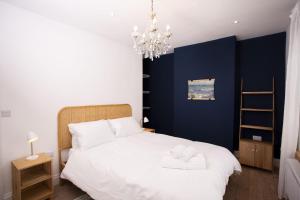 a bedroom with a large white bed with a chandelier at Ciliau in Cardigan