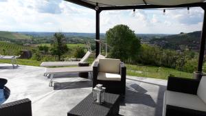 a patio with chairs and tables and a view at Agriturismo CasaMatilda in Dogliani
