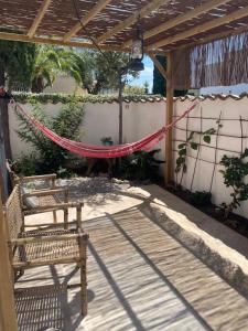 a patio with a hammock and a bench and a fence at Cabanon d’Amata in Saint-Raphaël