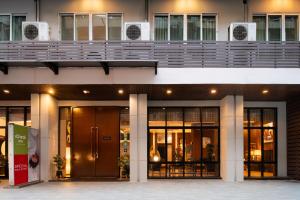 an office building with doors and windows and a balcony at iCheck inn Gems Center Silom in Bangkok