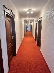 un couloir avec un tapis rouge dans un couloir dans l'établissement Hotel "XAVIER", à Lubycza Królewska