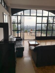 a living room with couches and a view of a patio at SSHC Apartments in Addis Ababa