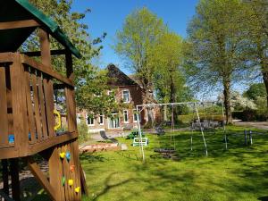 einen Hof mit einem Spielplatz mit einem Haus in der Unterkunft Ferienhof Bisdorf "Bauernhaus" in Bisdorf