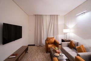 uma sala de estar com um sofá e uma televisão em Sun & Moon Bacca Hotel em Meca