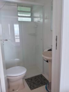 Baño blanco con aseo y lavamanos en HOTEL PORTO FINO en Pontal do Paraná