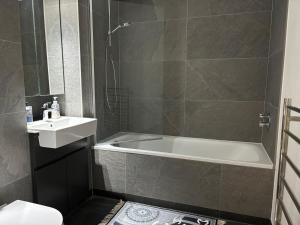 a bathroom with a bath tub and a sink at Double room with shares bathroom in Woolwich