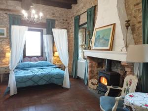 a bedroom with a bed and a fireplace at Agriturismo Casa Rastelli in Monteorsello