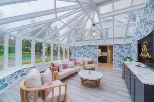 a conservatory with a glass ceiling and a living room at Windsor Oasis: Tranquil Retreat with Heated Pool in Windsor