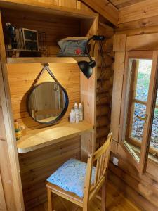 阿戈斯维达洛斯Camping écovillage Soleil du Pibeste的一个小房子里的镜子和椅子