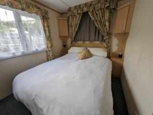 a bedroom with a large white bed with a canopy at The Senator 69 in Dunoon