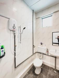 a white bathroom with a toilet and a sink at Urban ArtHouse Homestay - Permai, Sibu, Sarawak in Sibu
