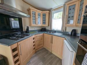 a kitchen with wooden cabinets and a stove top oven at The Senator 69 in Dunoon