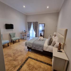 a bedroom with a bed and a table and a chair at Journey Guesthouse in Riversdale