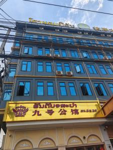 un edificio con una señal amarilla delante de él en 九号公馆, en Ban Dông-Naxôk