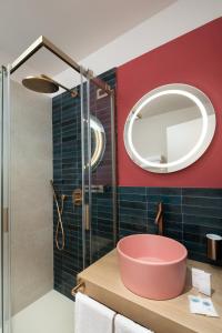 a bathroom with a pink tub and a mirror at Tanka Selected in Villasimius