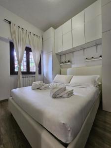 una camera bianca con un grande letto con armadi bianchi di ROME HOLIDAY QUIET AND CONFORTABLE APARTMENT a Roma