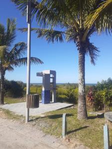 a monument between two palm trees in a park at HOTEL PORTO FINO in Pontal do Paraná
