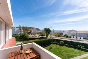 a balcony with a table and a bottle of wine at Acolhedor apartamento com Wifi a passos do Mar in Luz