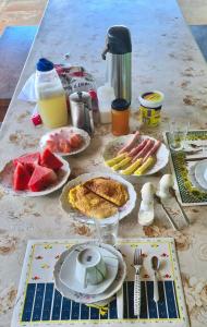 einen Tisch mit Teller mit Lebensmitteln und Obst darauf in der Unterkunft HOTEL FAZENDA BOLANDEIRA in Conde