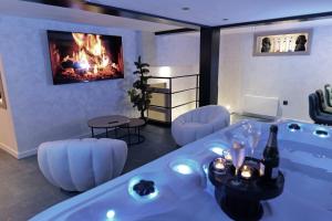 uma sala de estar com banheira e lareira em Bali Suite em Besançon