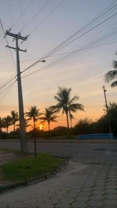 an empty street with palm trees in the sunset at HOTEL PORTO FINO in Pontal do Paraná