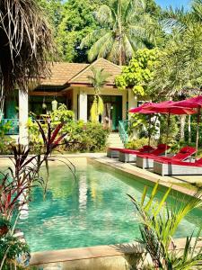 a swimming pool in front of a house at Carpe Diem Residence in Thongsala