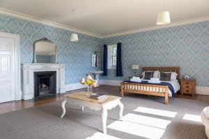 a living room with a bed and a fireplace at Magnificent Period Country House in Rothley