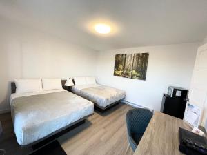 ein Hotelzimmer mit 2 Betten und einem Tisch in der Unterkunft Motel Saint Bruno in Saint-Bruno-de-Montarville