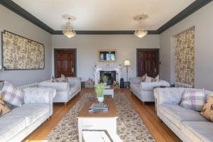 a living room with couches and a coffee table at Magnificent Period Country House in Rothley