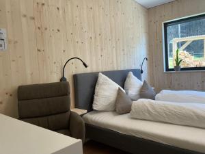 um quarto com um sofá, uma cama e uma janela em Waldblick - modern wohnen - Self-Check-In - direkt am Wald - kein Verkehr - in 10 Minuten im Innsbrucker Zentrum - vorm Haus parken em Innsbruck