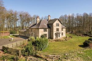 an old house on a hill with a yard at Magnificent Period Country House in Rothley